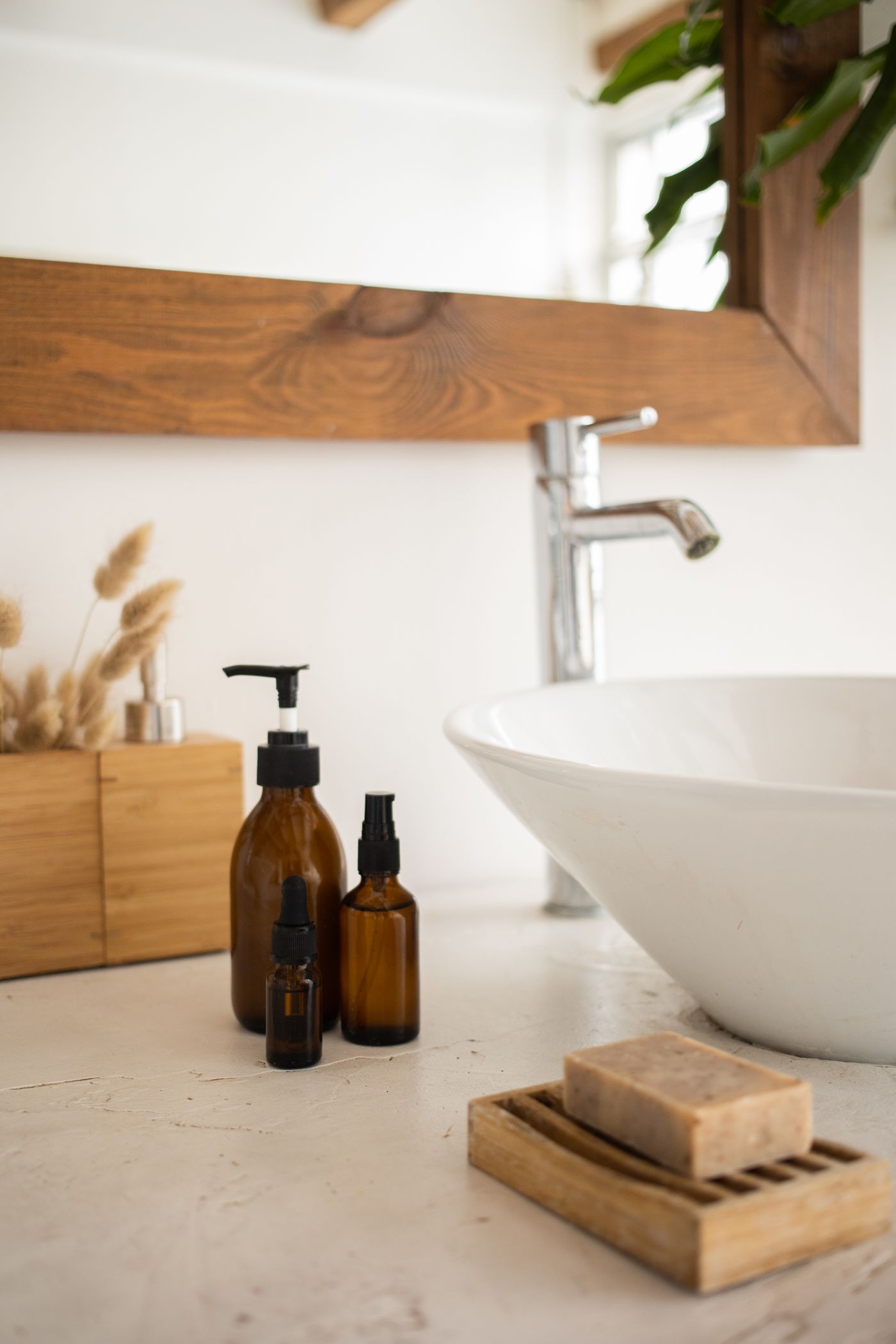 Skincare bottles arranged beside a sink in a real bathroom