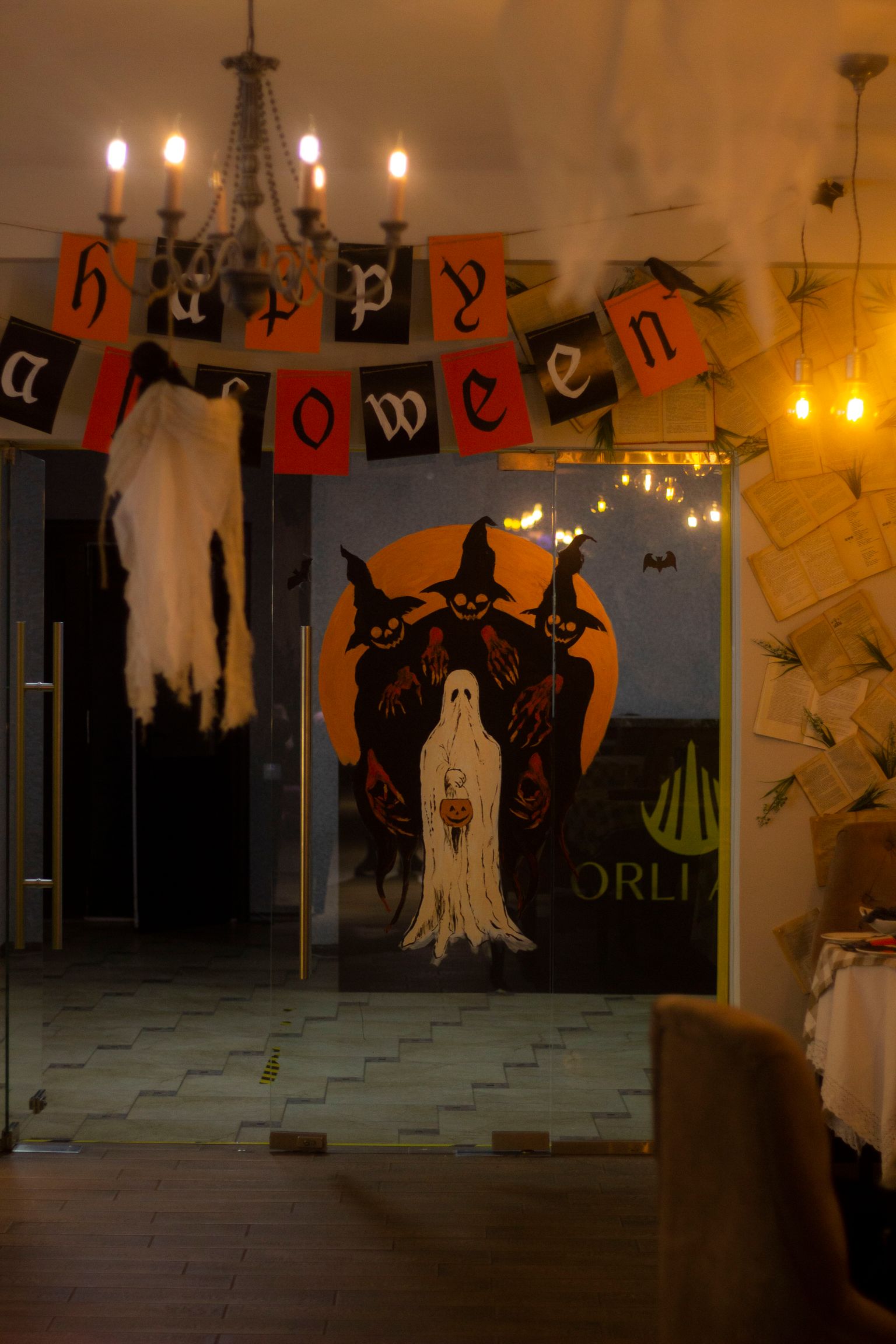 A real room decorated for Halloween with pumpkins, ghosts, and a seasonal banner